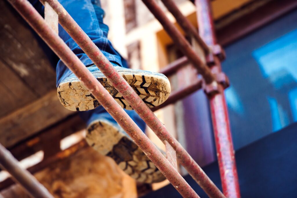 Detail of legs of unrecognizable man standing on scaffold