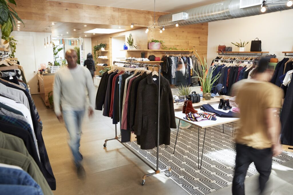 People walking through a busy clothes shop, motion blur