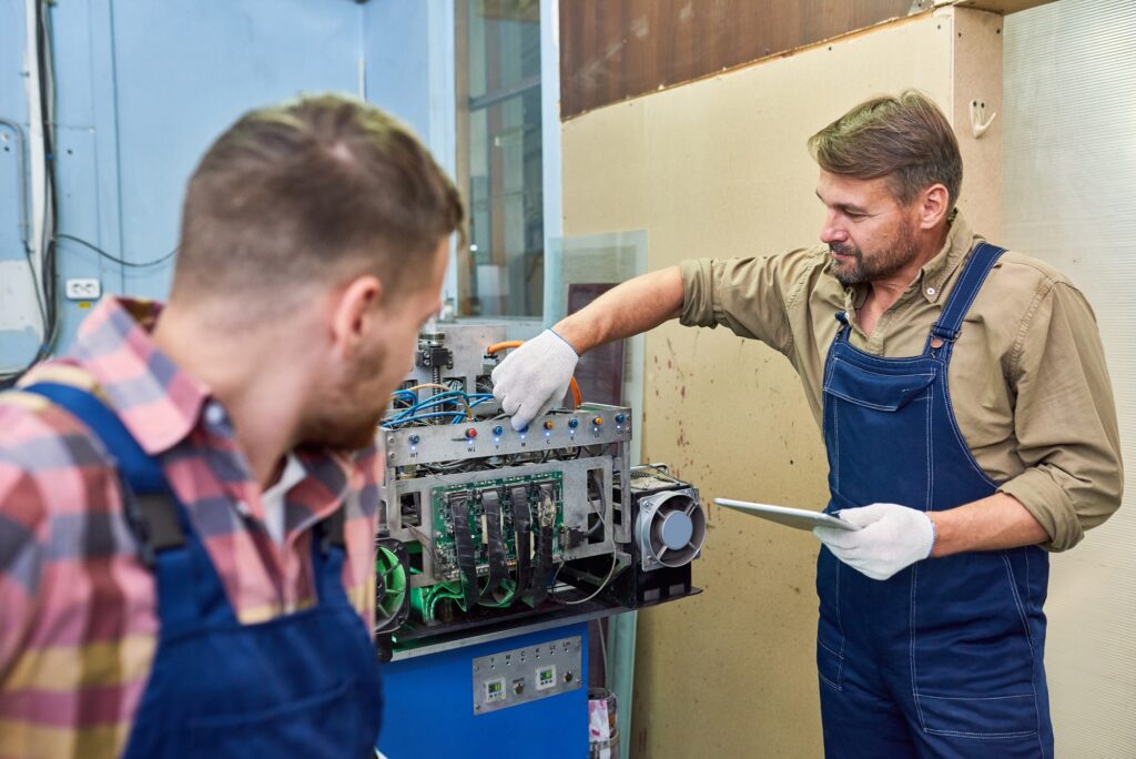 Two Mechanics Fixing Machine at Factory