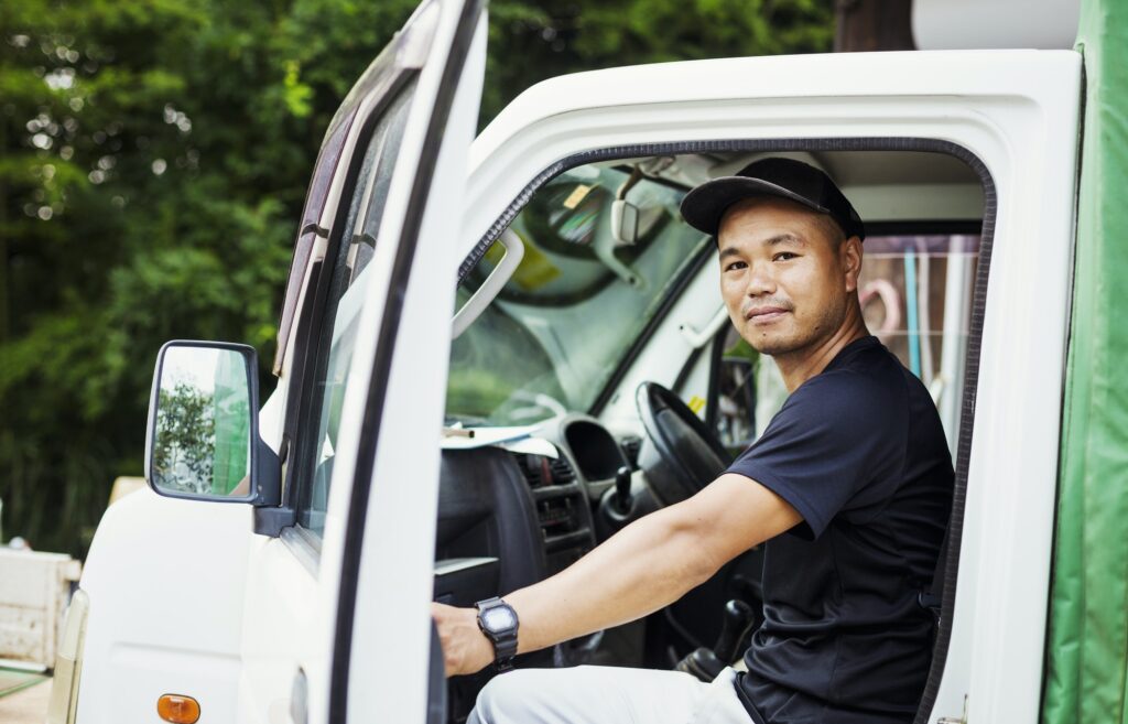 A young man sitting in a truck at a commercial farm in Japan.