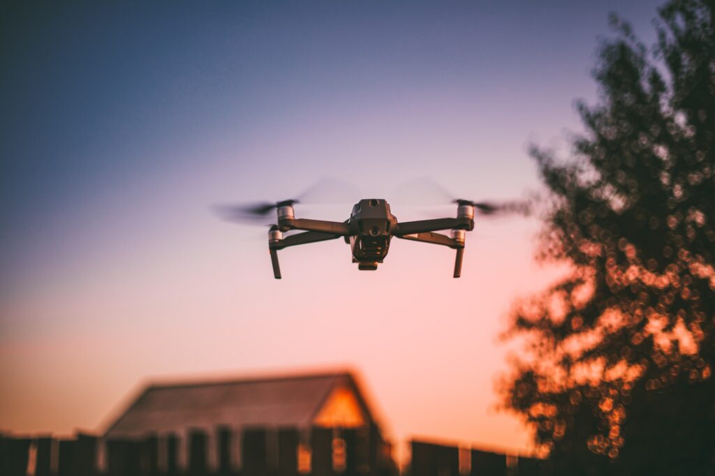 Flying Electric Drone On Sky At Sunset Sunrise