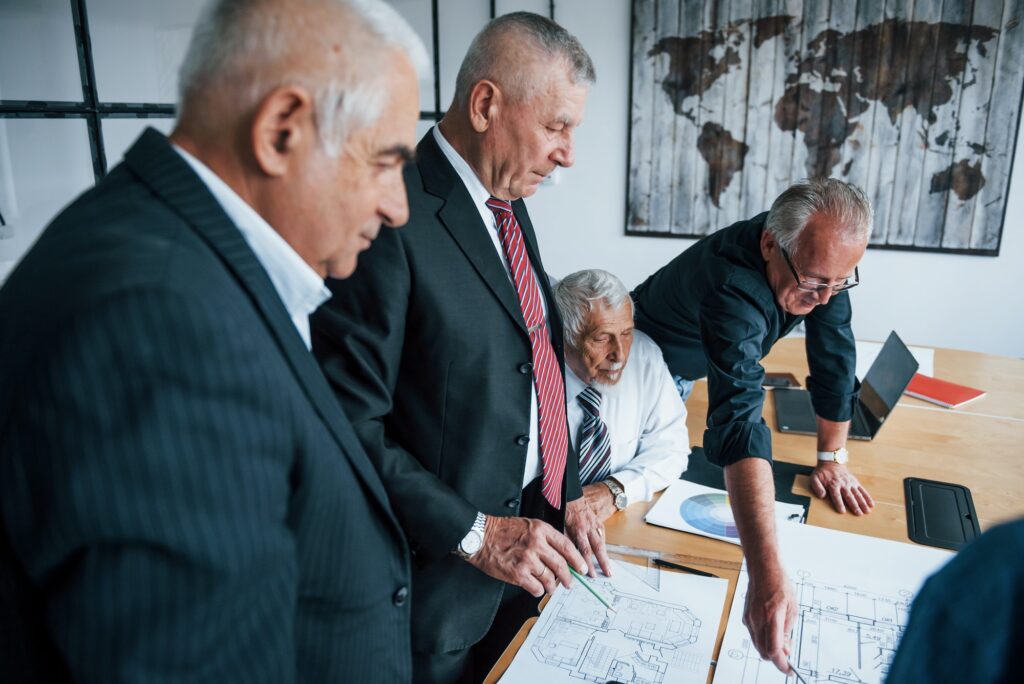 Aged team of elderly businessman architects have a meeting in the office