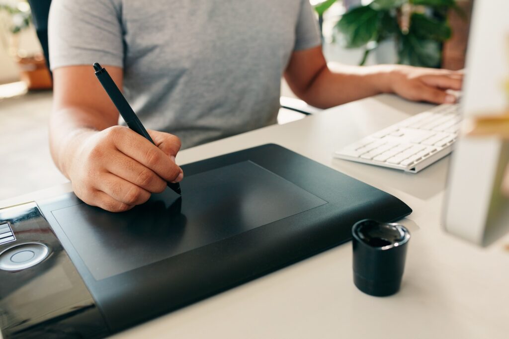 Graphic designer using digital tablet and computer in the office