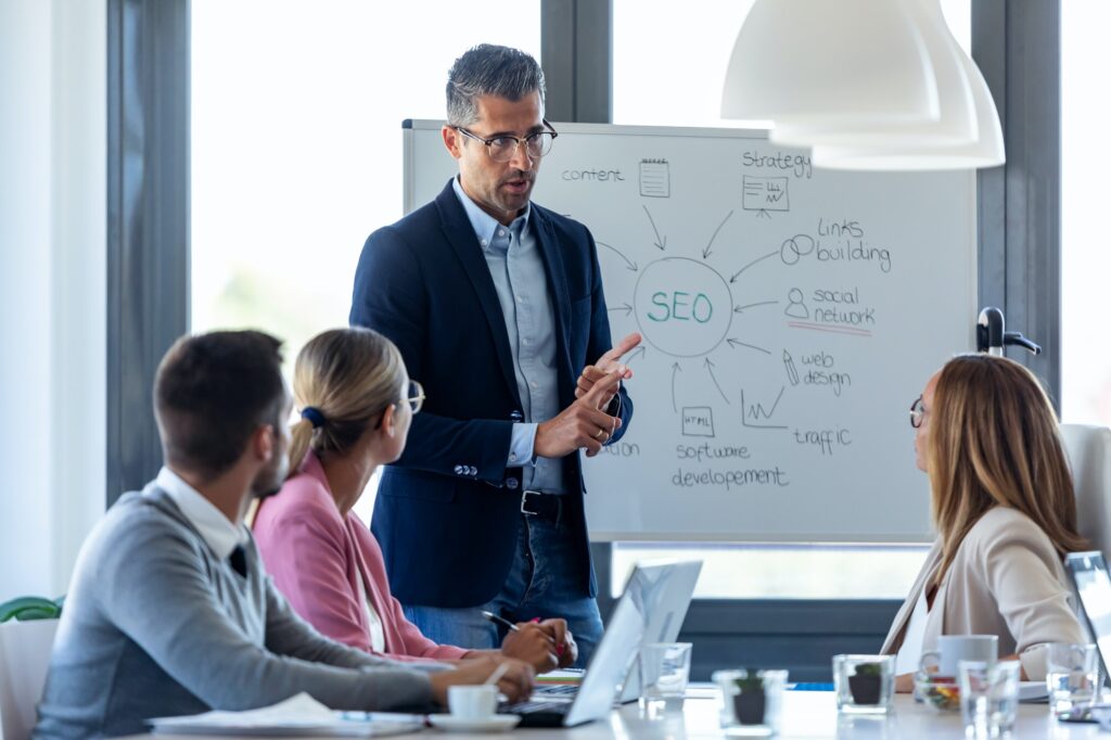 Handsome businessman explaining a project to his colleagues on coworking place.