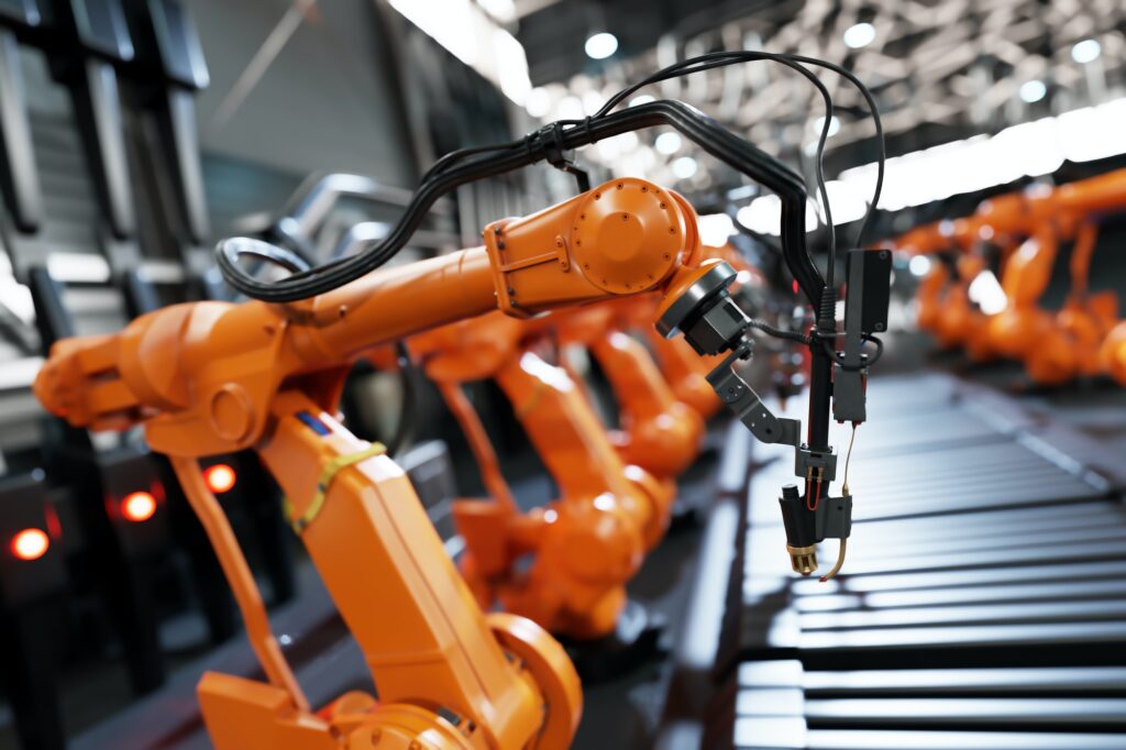 Robotic arms along assembly line in modern factory.