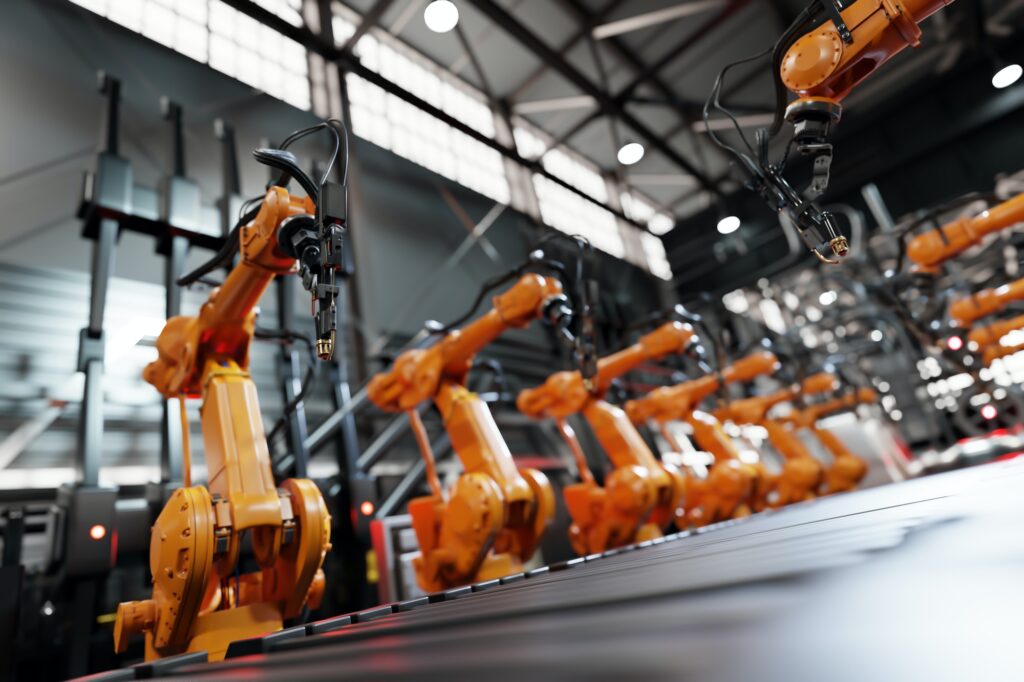 Robotic arms along assembly line in modern factory.