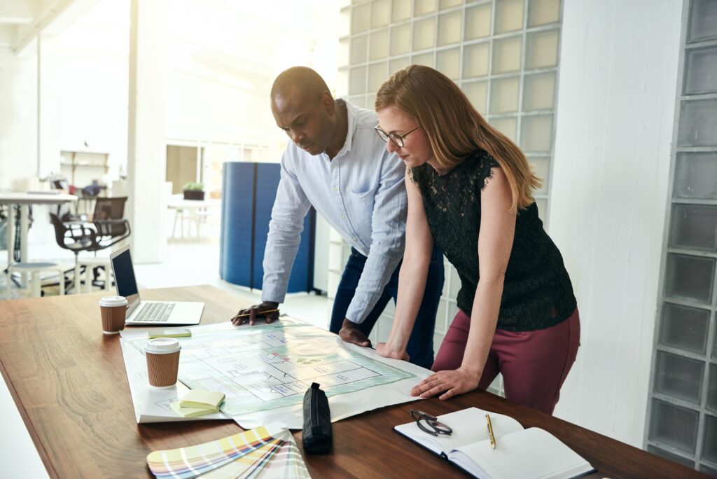 Two architects discussing a building design in an office