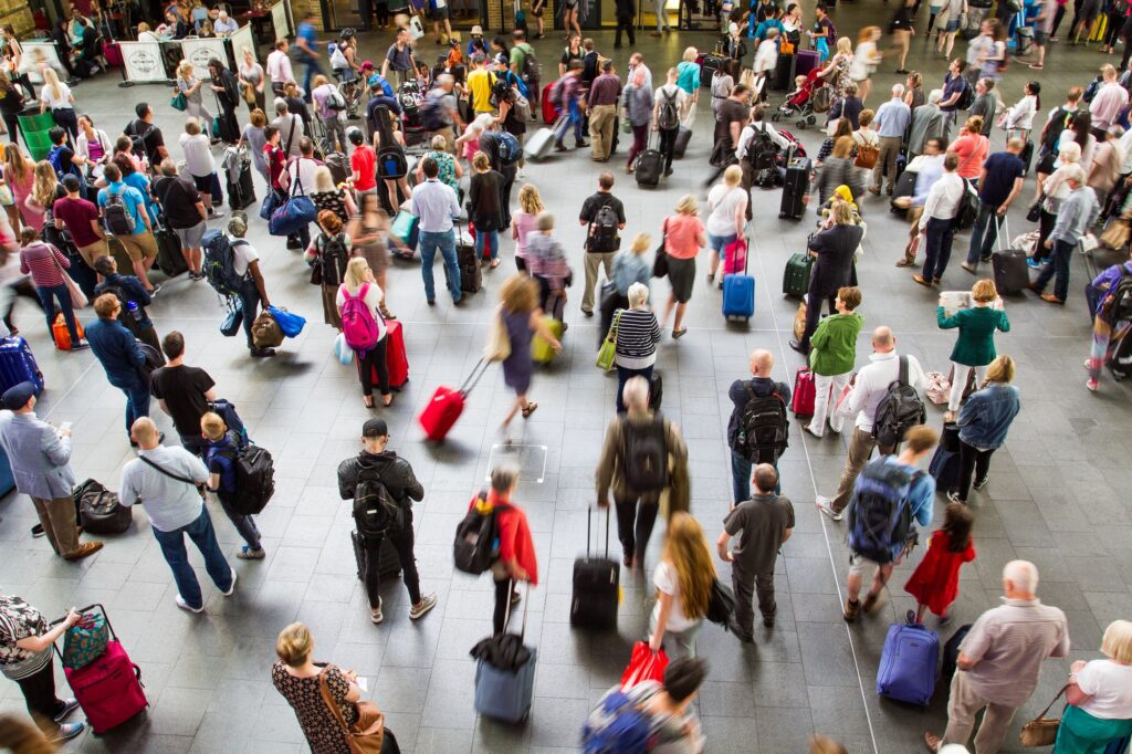 An aerial view of a crowded Kings Cross train station in London packed full of commuters