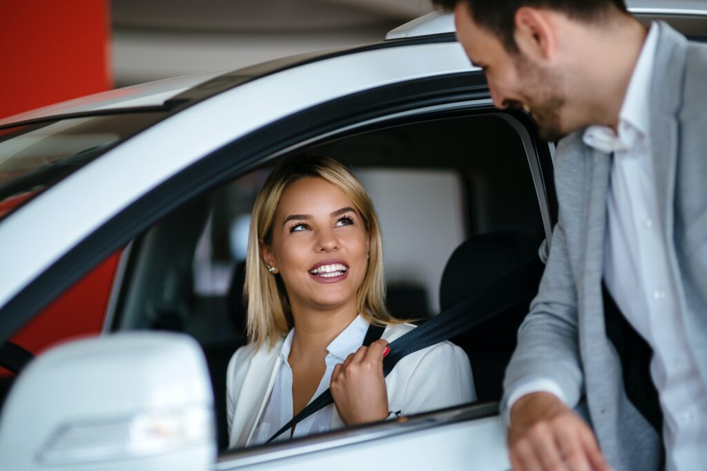 Handsome salesman at car dealership selling vehichles