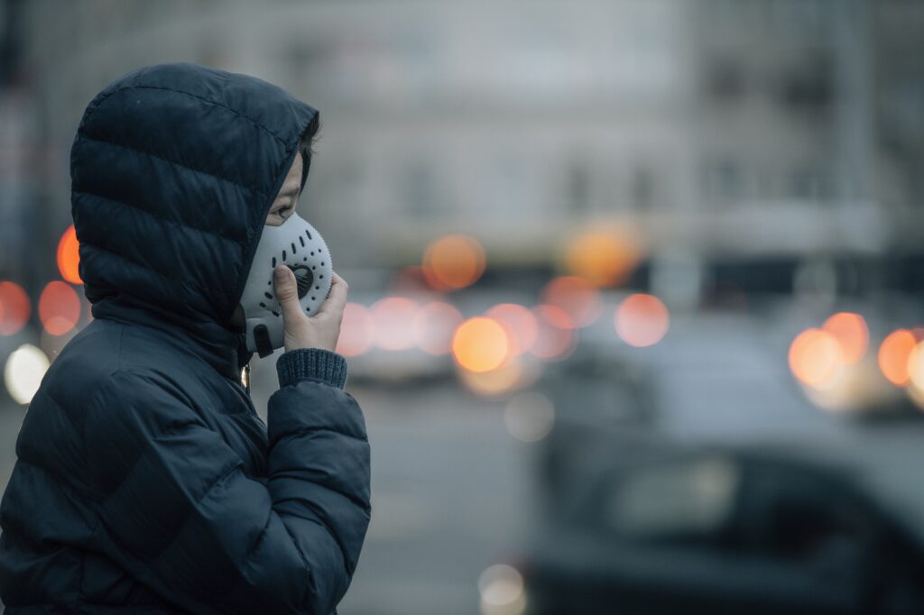 Polluted Air in a City Street; Child with Anti-Pollution Breathing Mask