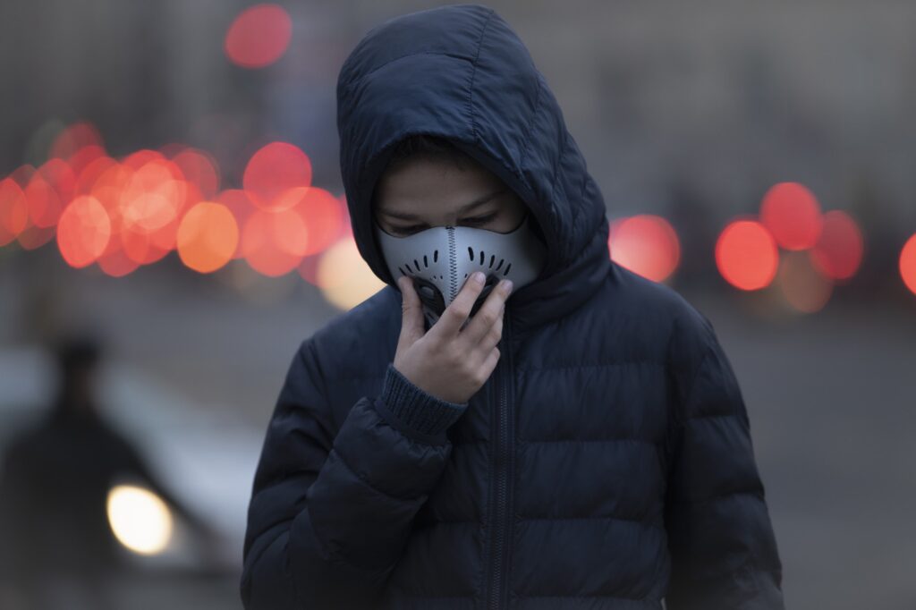 Young Person wearing Anti-Pollution Mask, Polluted Air, City Street